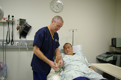 A registered nurse adjusting a bandage on a patient's arm
