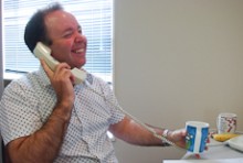 Sean Fitzgerald laughs while talking to a client on the phone