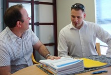 Sean Fitzgerald looks through a folder of financial statements with a client