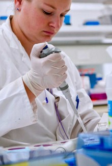 A female scientist in a laboratory filling test pottles with an injector