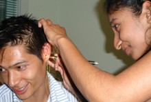 Renuka Foneksa fitting a hearing aid on a client