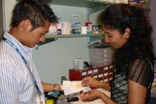 Two people in an audiology clinic looking at equipment