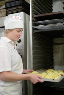 Stacey Johnson taking sausage rolls from the oven