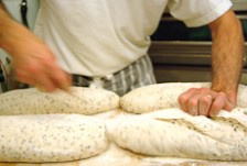 Max Fuhrer makes diagonal cuts in an unbaked loaf