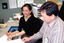 Two clinical coders talking at a desk