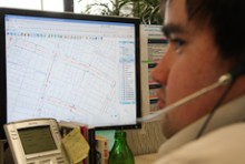 Peter Bradley, wearing a headset, at his computer which shows street maps
