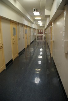 A prison corridor with cell doors on both sides