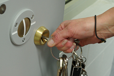 A hand on a bunch of keys locking a prison cell door
