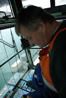 Warren Stoddart inside a crane cab watching a container he is shifting