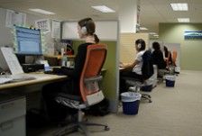 Three court reporters sitting at separate cubicles