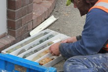 A man sitting next to a tray of soil samples