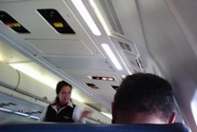 A flight attendant walking down the aisle of a plane