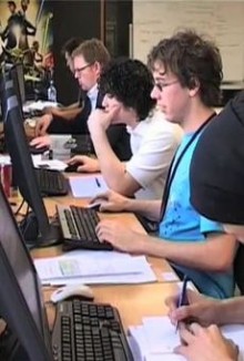 A team of four game developers sitting in front of their terminals creating a computer game