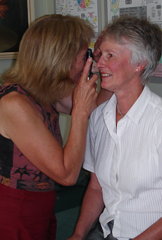 Tessa Jones looks through an instrument at a patient's eye