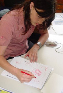 Lauren Robertson sketches a design on a piece of paper.