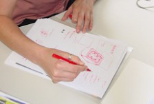 Close-up of a graphic designer drawing a design on a piece of paper.