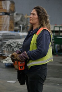Renee King using a remote control to lift a container from her truck