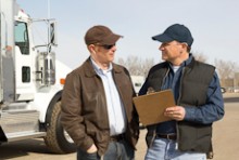 Two truck drivers talking in front of a truck