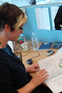 Laura Feasey looking at a manual