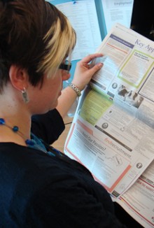 Laura Feasey reading a newspaper.