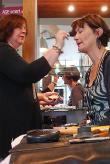 Natalie Young putting make-up on a customer in a salon