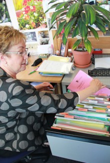 Robyn Pask removing a folder from a filing cabinet