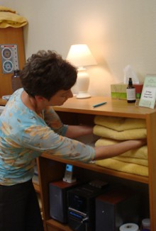 Paula Cox selecting a towel from a pile of towels.