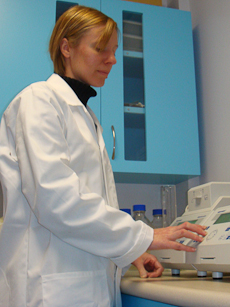 Tina Summerfield pressing buttons on a piece of laboratory equipment