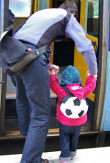 Louise Carr-Smith helping a child step into a train.