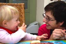 Louise Carr-Smith supervises a toddler eating a banana.