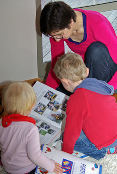 Louise Carr-Smith looking at books of photos with two children