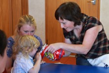 Vicky Sweeney holding a bag of chips out to a young boy