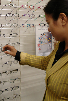 Marama Lambert selecting a pair of glasses from the shop range on display.
