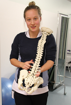 Nadia Larsen pointing to a model of a human spine