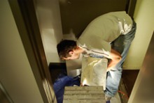 Mark Holton bending down to get a scoop of plaster from a bucket