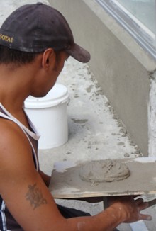 Owen McCarthy holding a plasterers hawk on which is a scoop of cement
