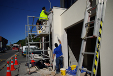 Plasterers standing on scaffolding working on the exterior of a building