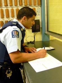 Jana standing at a counter completing a form