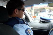 Jana sitting in the passenger seat of a police car
