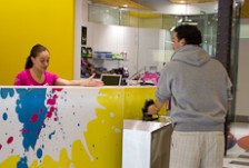 Tepora Stowers sitting behind a reception greeting a customer