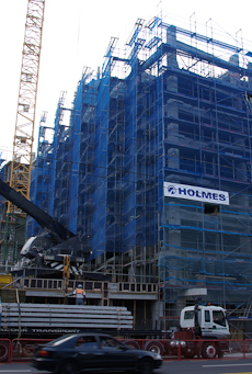 Scaffolding covered in blue see-through cloth netting at a building site