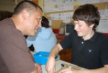 Craig Rofe watching a student do a physics experiment