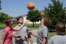 Lara Coker throwing a basketball up in the air for three students