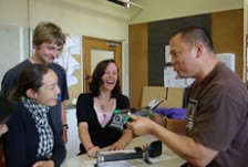 Craig Rofe talks to three students in a physics class