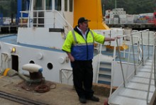 Paul Wilson standing beside the gangplank of his ferry