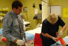 Richard Keddell watching a colleague examine a foot in plaster