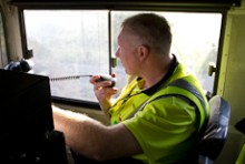 Jim Featherstone talking into a two-way radio in the cab of a locomotive