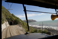 A view out of the front window of a locomotive as it approaches a tunnel