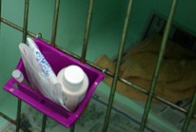 A set of medicine in a container on a cage door