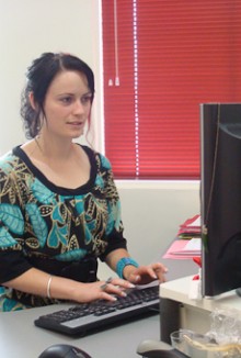 Larissa Donaldson looking at a computer screen as she types on a keyboard